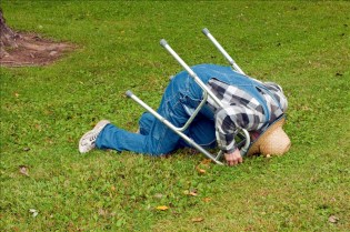 elderly man with a walker takes a tumble in the park