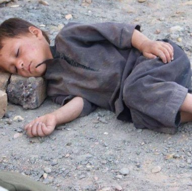 kid asleep on rock
